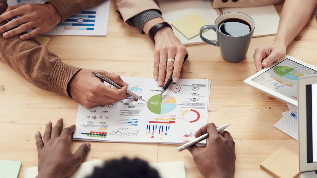Charts, notes and a tablet spread across a table during a planning session